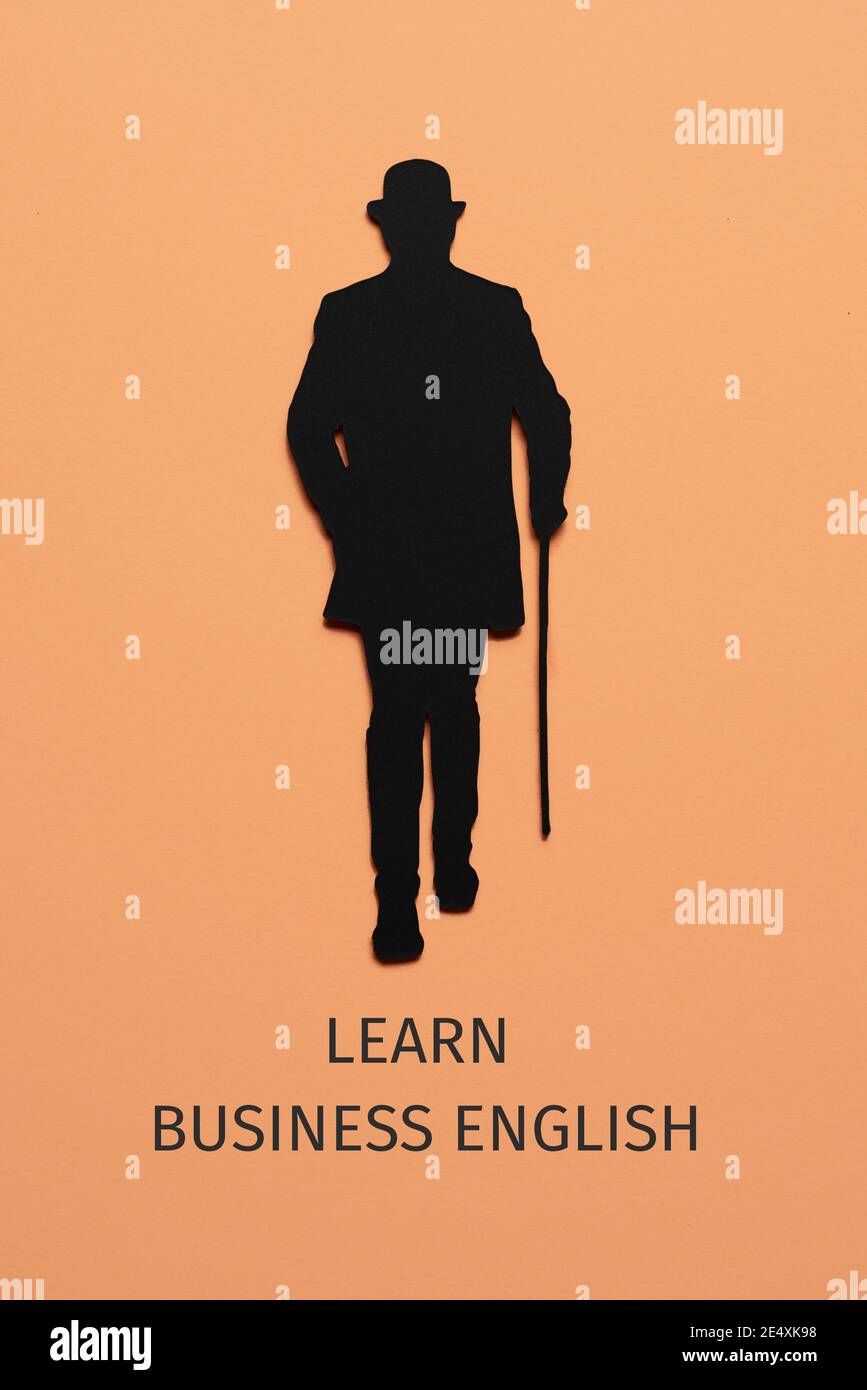 la silhouette di un uomo elegante, che indossa cappello e utilizzando un bastone da passeggio, ritagliato su un cartoncino nero, e il testo parlano inglese commerciale su un pallido o. Foto Stock