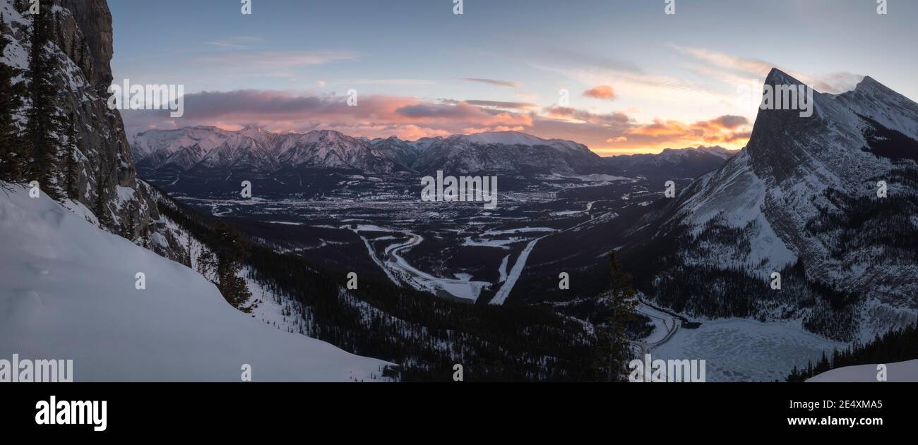 Una vista panoramica dell'alba dall'estremità est del Monte Rundle che guarda sulla città di Canmore e ha Ling Peak attraverso il varco della valle. Foto Stock