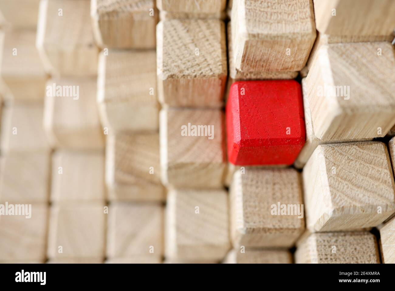 Piramide di cubetti di legno beige, uno di loro è rosso Foto Stock