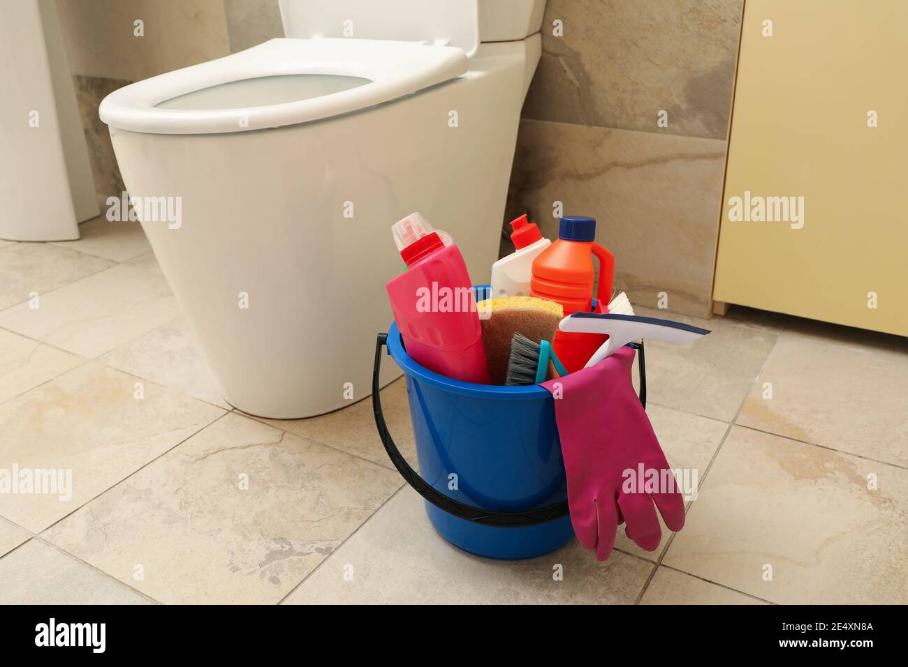 Secchio con prodotti per la pulizia in un bagno moderno, un set pronto di prodotti per la pulizia per l'igiene domestica Foto Stock