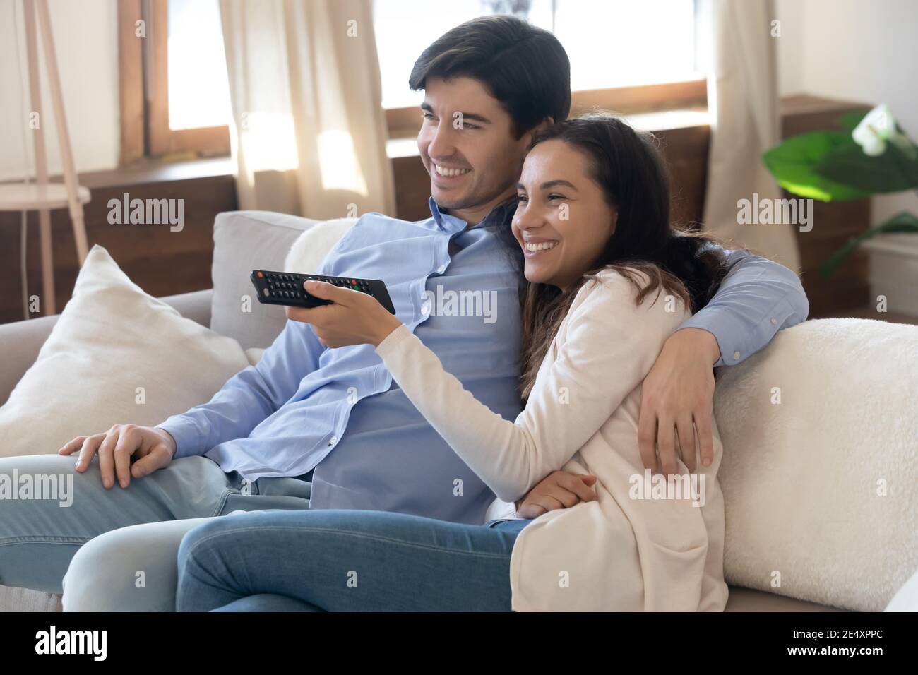 Primo piano felice giovane coppia abbracciando, guardando la tv insieme Foto Stock