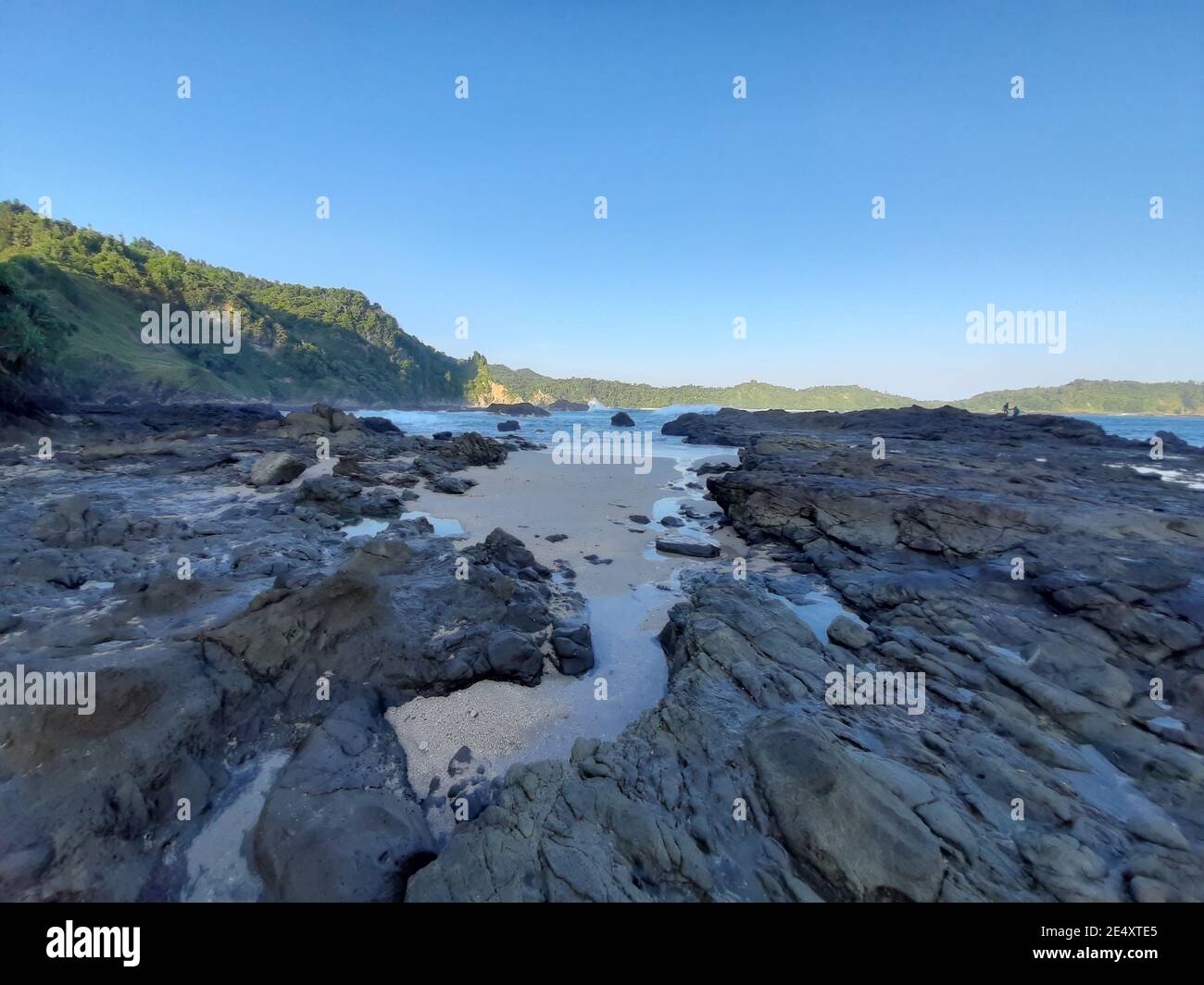 Un vasto altopiano roccioso mescolato con sabbia e acqua da onde di mare Foto Stock