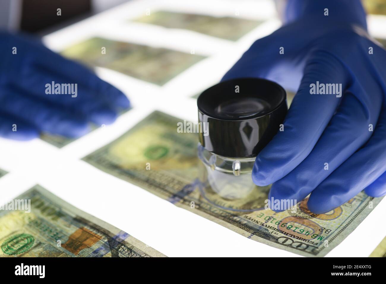 L'esperto controlla l'autenticità delle banconote. Contraffazione e tipi di frode Foto Stock