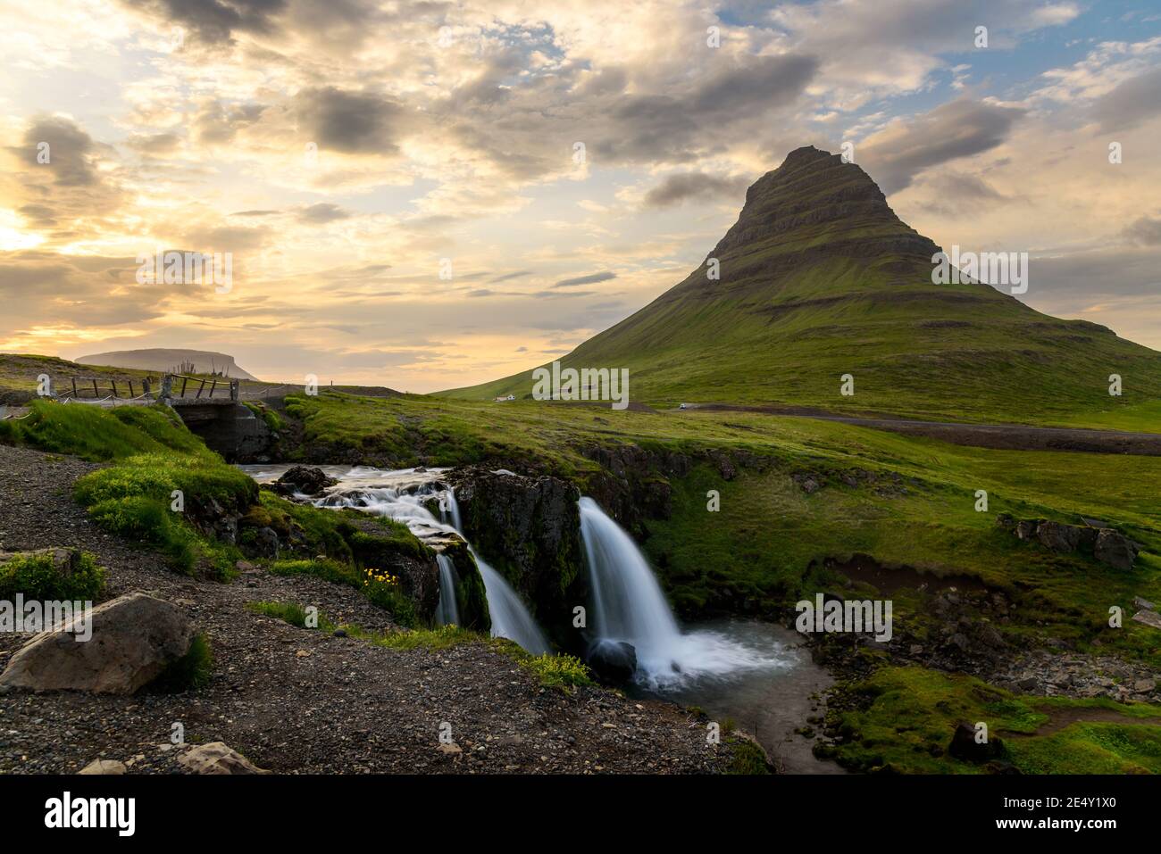 Vista sul monte Kirkjufell e sulla cascata illuminata dal sole di mezzanotte in estate Foto Stock