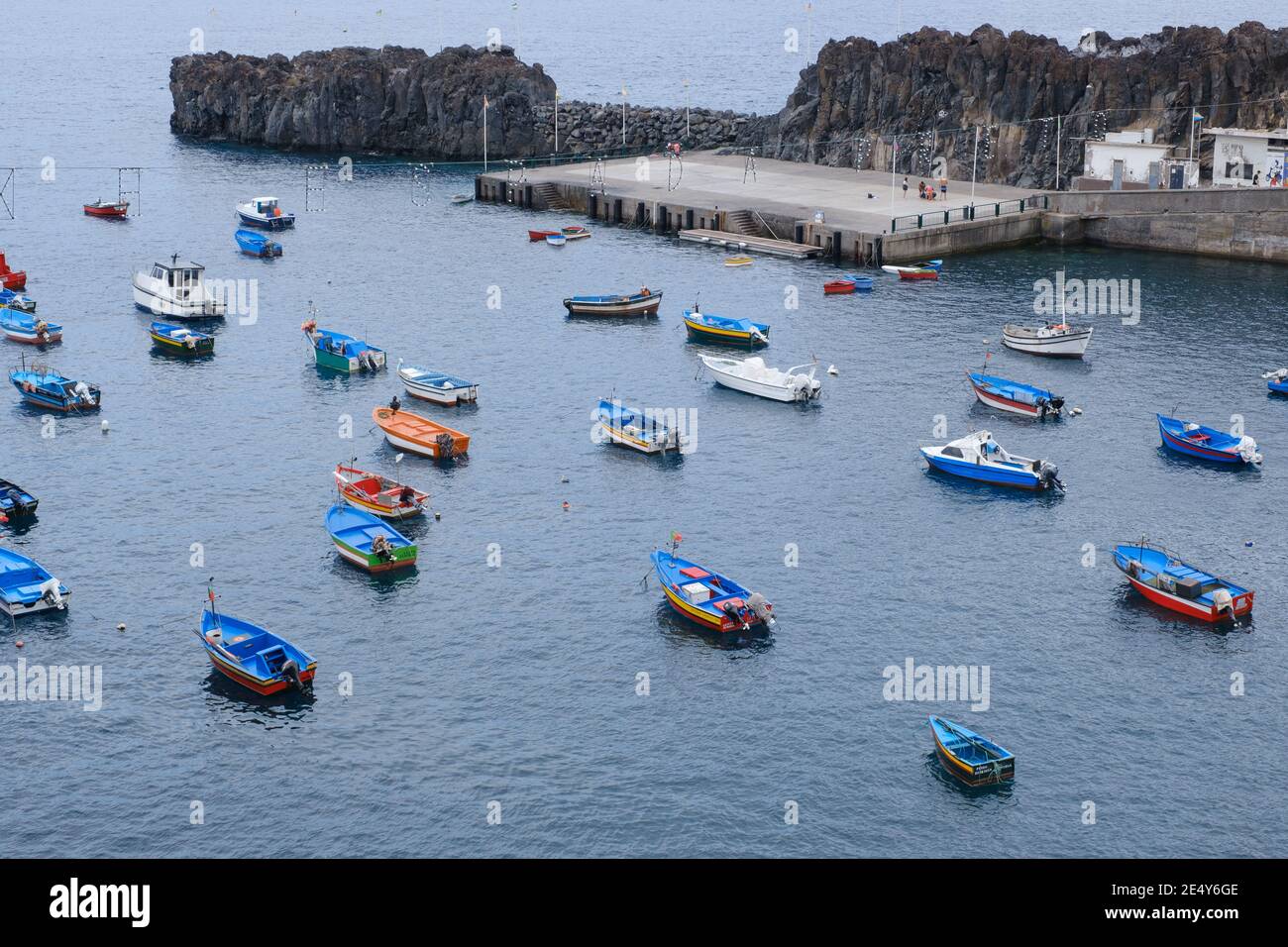 molte barche colorate di pescatori nell'acqua dell'oceano vicino a. porto durante una fredda mattina Foto Stock