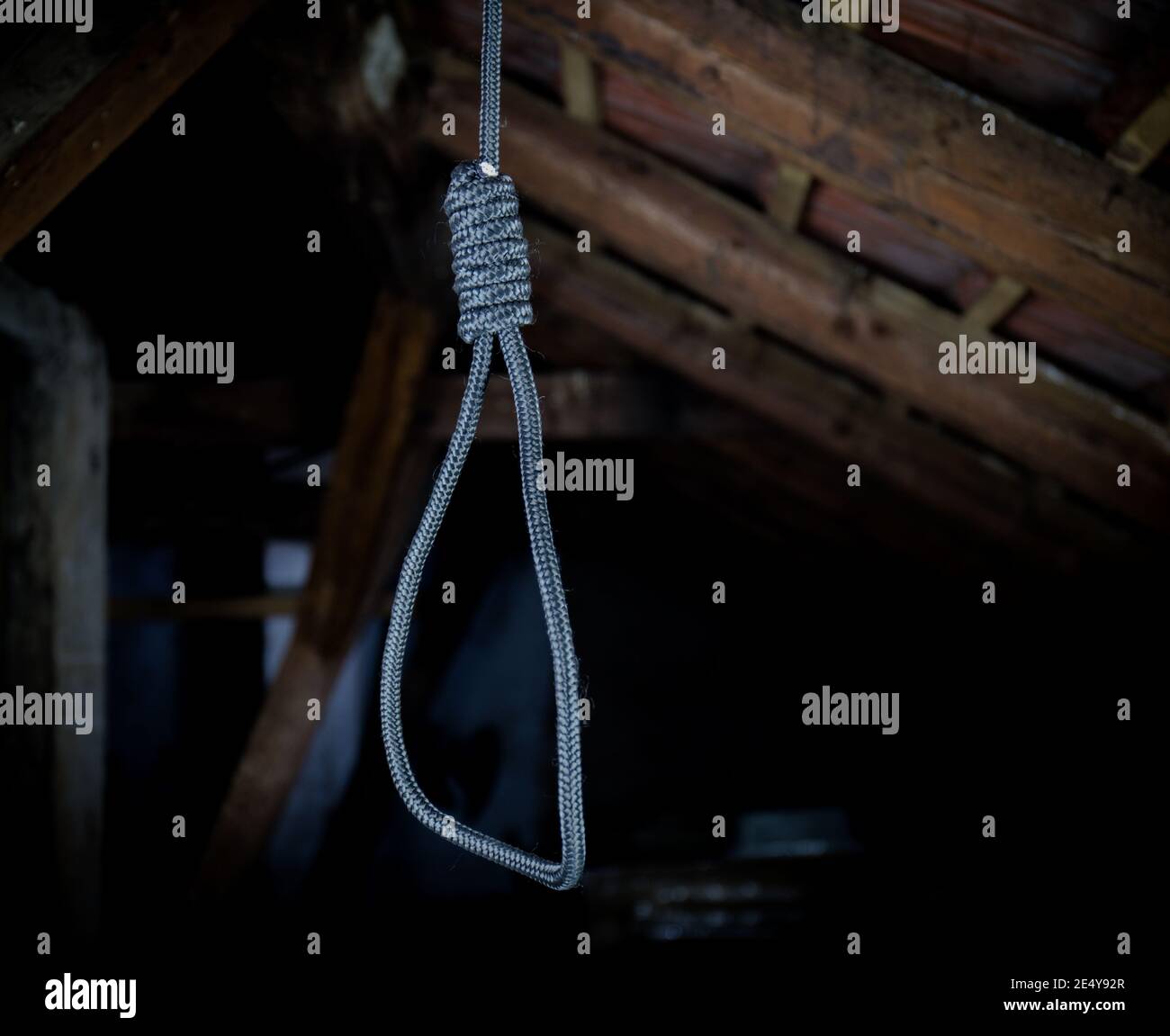 Un cappio appeso intorno al collo, un suicidio commesso, scene orribili in un soffitta oscura Foto Stock