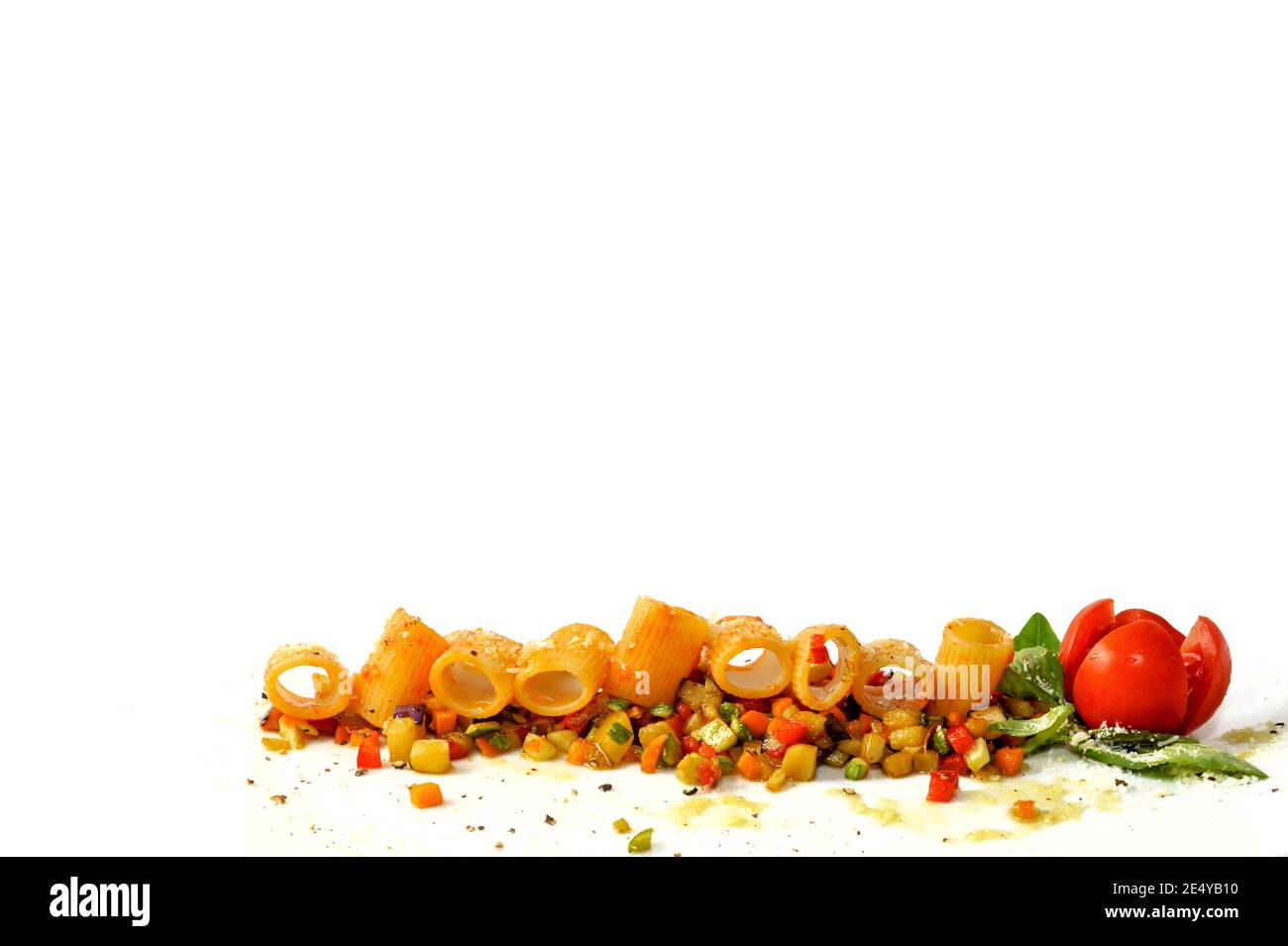 mezze maniche con salsa di pomodoro su verdure cotte tagliate con pomodoro di ciliegia e foglie di basilico isolate su sfondo bianco alla base del fr Foto Stock