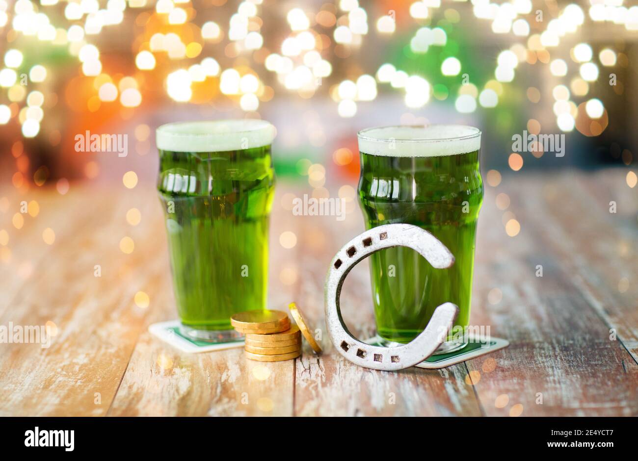 Bicchieri di birra verde, a ferro di cavallo e monete d'oro Foto Stock