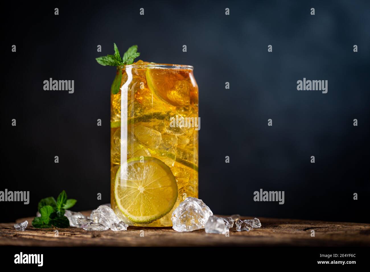 Bevanda estiva tè freddo con fette di limone e menta sfondo scuro Foto Stock
