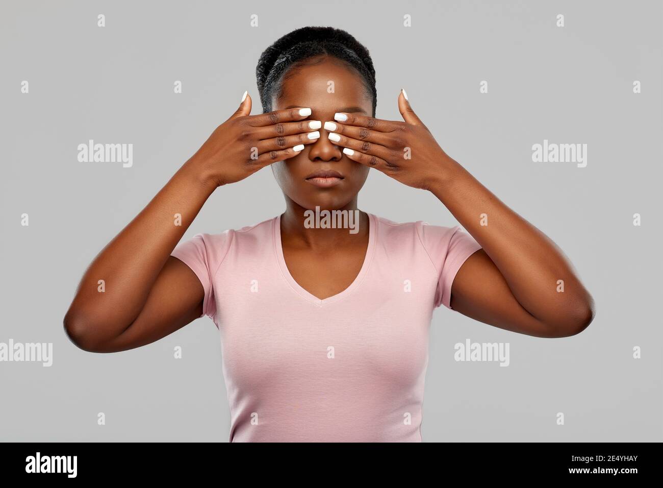 African American donna con gli occhi chiusi con le mani Foto Stock