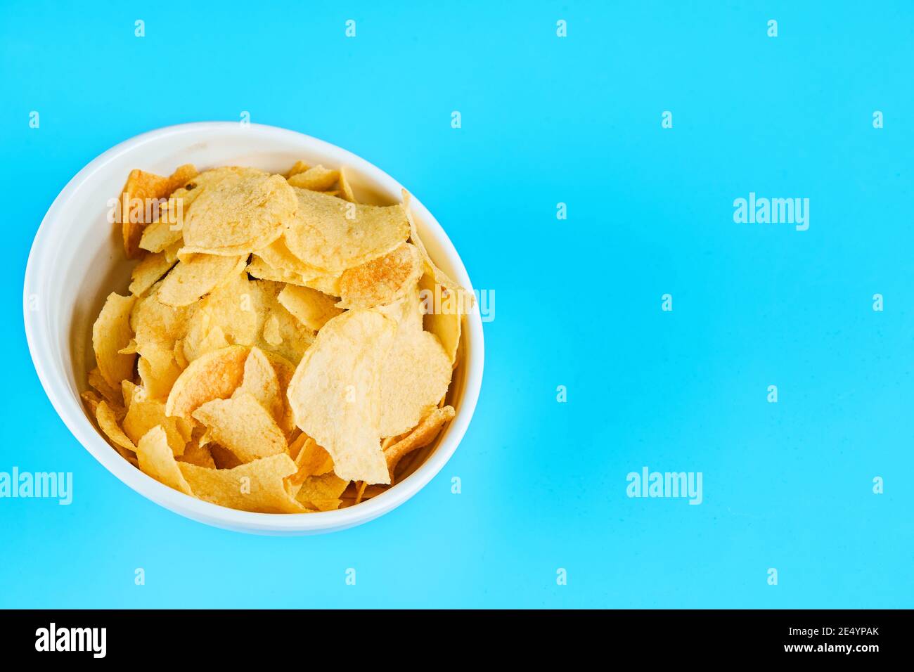 Ciotola di patatine croccanti su sfondo blu Foto Stock
