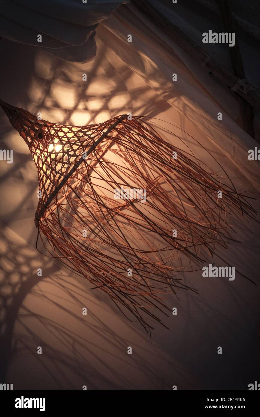 Lampada di bambù in stile boho moderno, tropicale, bohémien con ombre sulle pareti Foto Stock