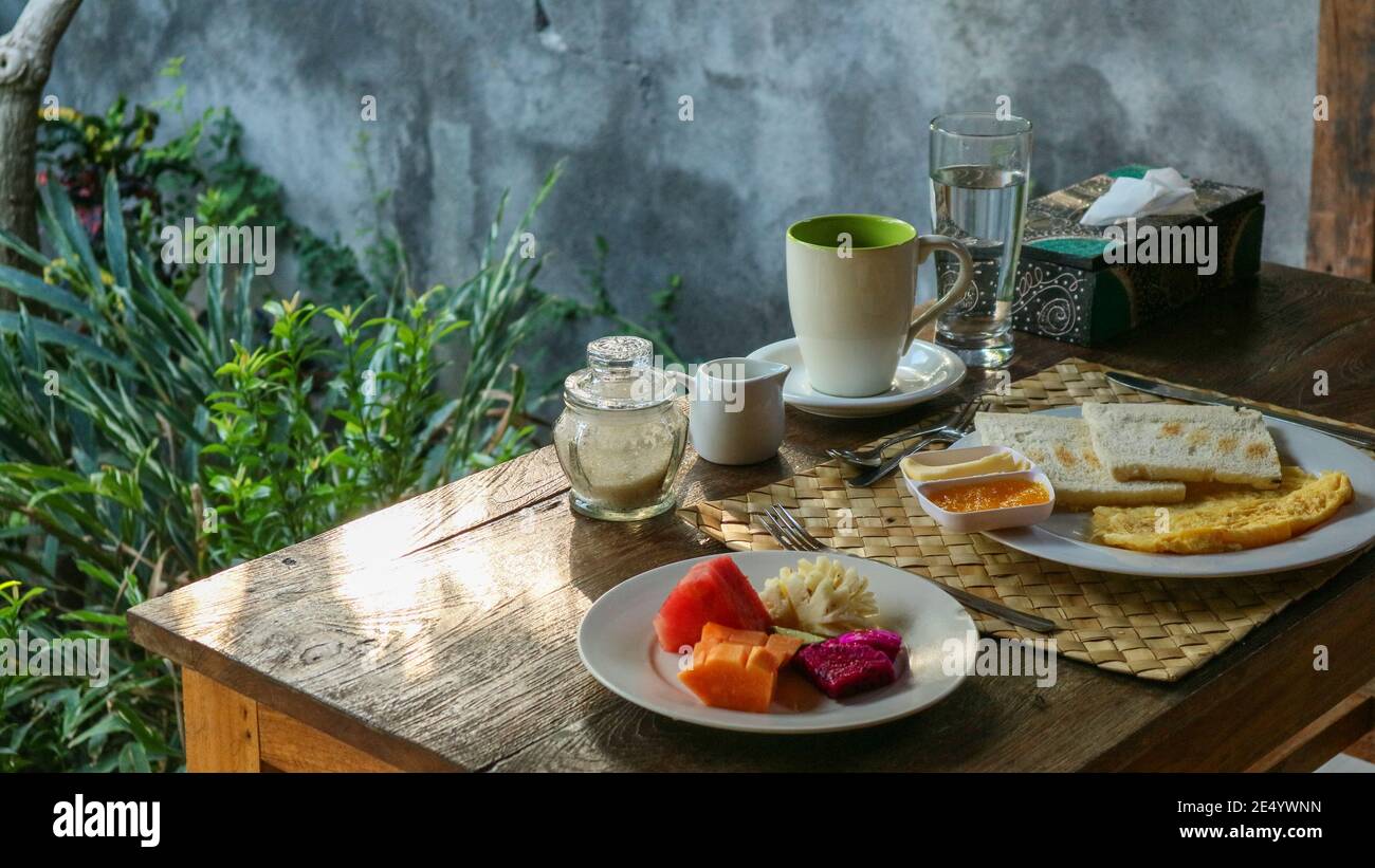 Colazione turistica tradizionale a Bali: Toast, uova strapazzate, caffè e frutta fresca Foto Stock