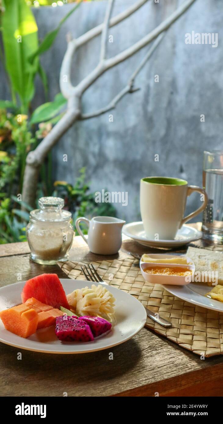 Colazione turistica tradizionale a Bali: Toast, uova strapazzate, caffè e frutta fresca Foto Stock