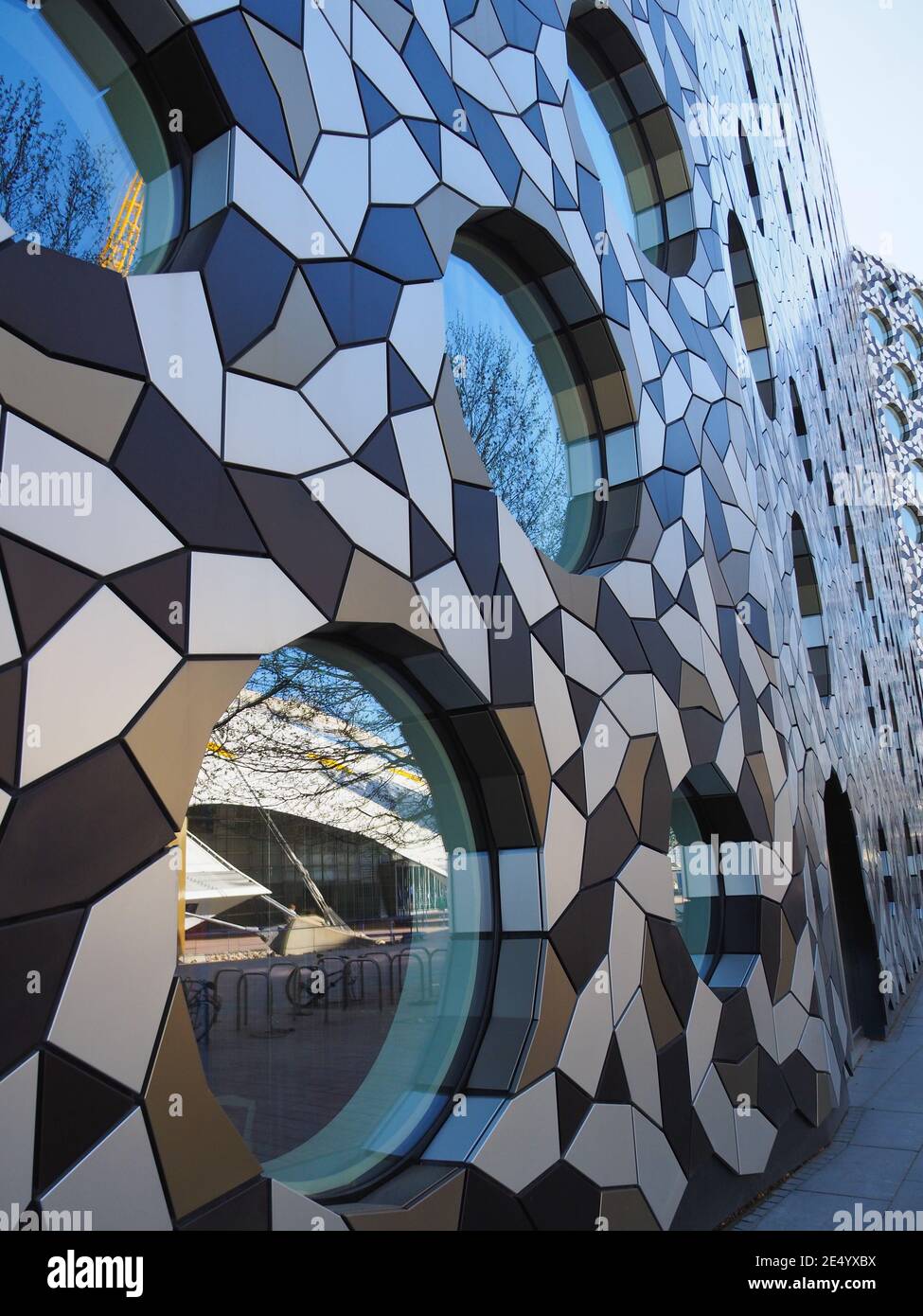 Primo piano di un moderno edificio artistico vicino all'arena O2 in Londra con finestre circolari Foto Stock