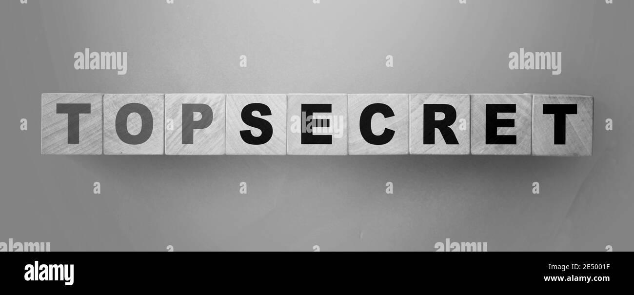 Parole Top segreto su cubetti di legno su sfondo verde. Commercio o concetto di affari segreti di profitto grande. Foto Stock