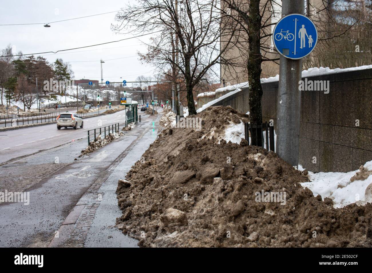 La pista da neve sporca blocca il marciapiede nel quartiere Taka-Töölö di Helsinki, Finlandia Foto Stock