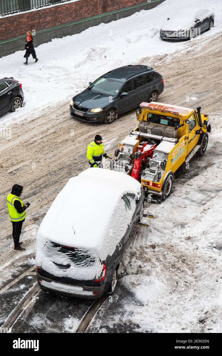 L'automobile è stata trainata via per permettere la rimozione e la rimozione della neve su Messeniuksenkatu nel distretto di Taka-Töölö di Helsinki, Finlandia Foto Stock