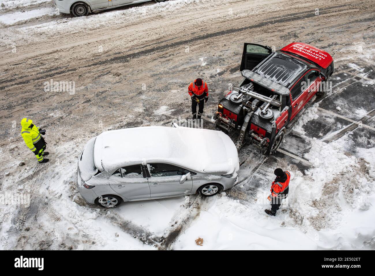 L'automobile che - nonostante la richiesta di rimozione - ostacola o ostruisce lo sgombero della neve è stata trainata via nel distretto di Taka-Töölö di Helsinki, Finlandia Foto Stock