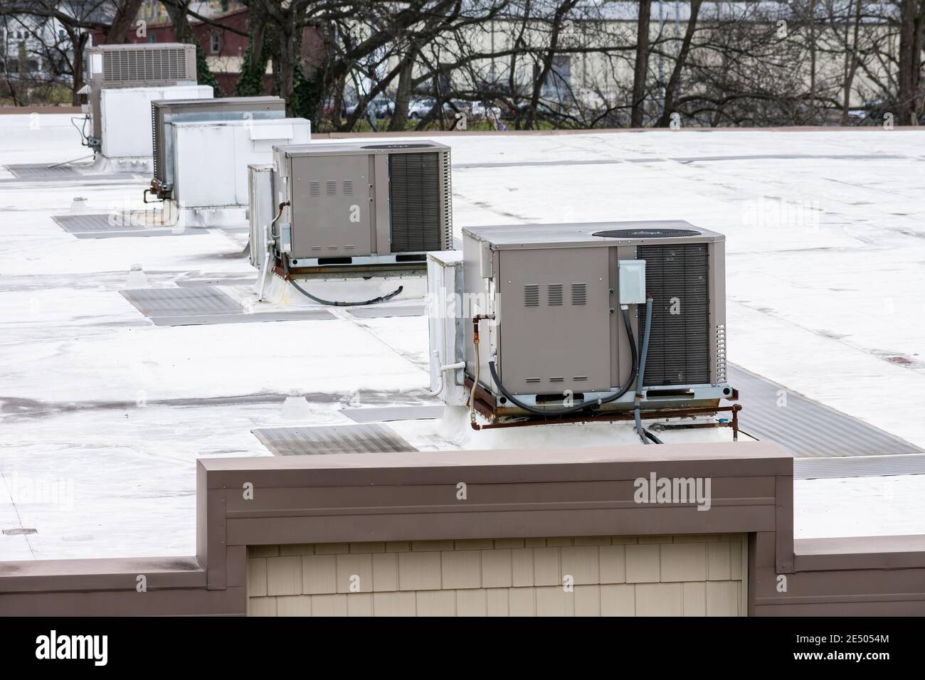 Immagine orizzontale di una fila di unità di climatizzazione sul tetto sopra un edificio di un ufficio medico. Foto Stock