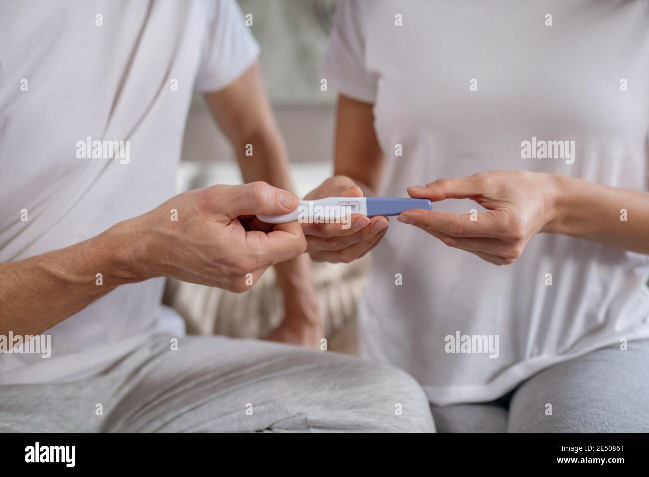 Donna che condivide i risultati del test di gravidanza con suo marito Foto Stock