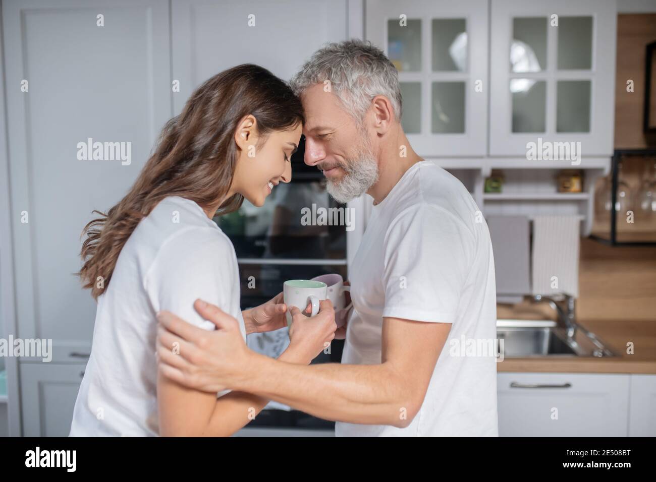 Uomo e donna si abbracciano mentre si ha il caffè Foto Stock