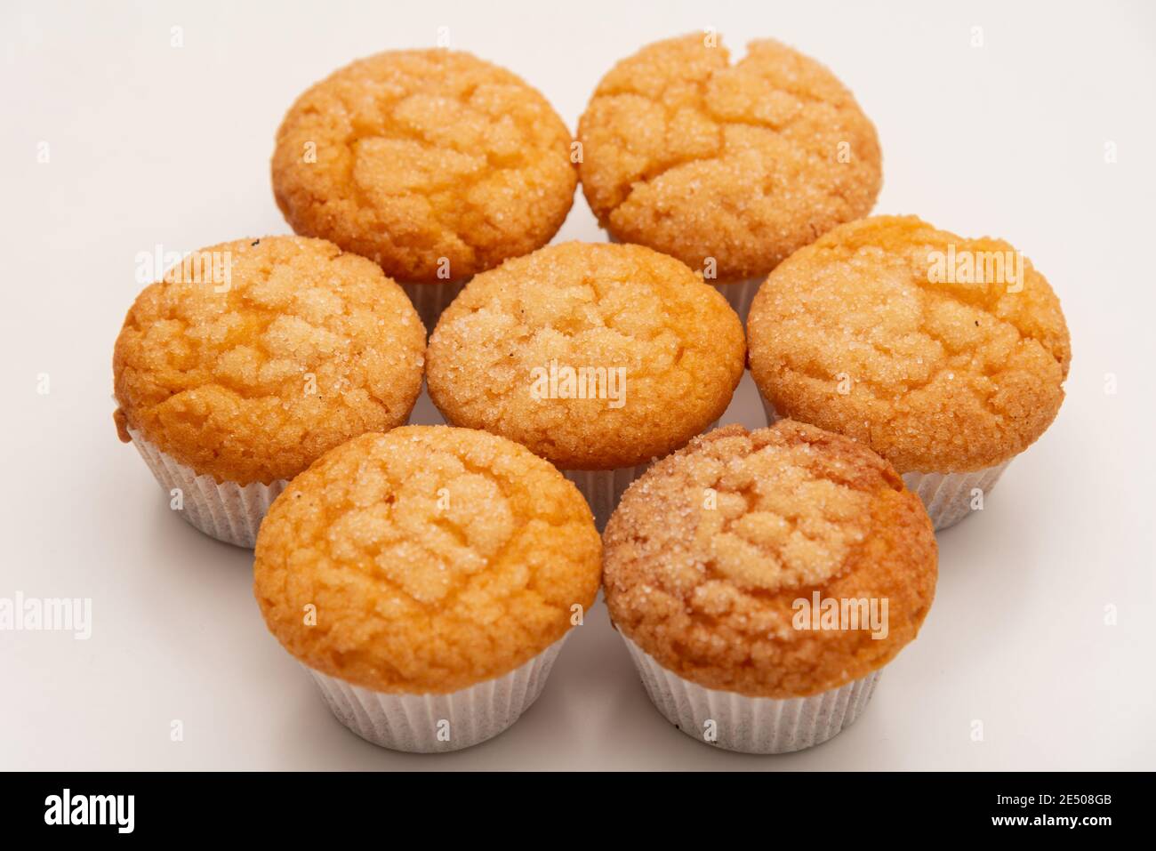 Gustosi muffin rivestiti di zucchero appena sfornati su un tavolo bianco Foto Stock