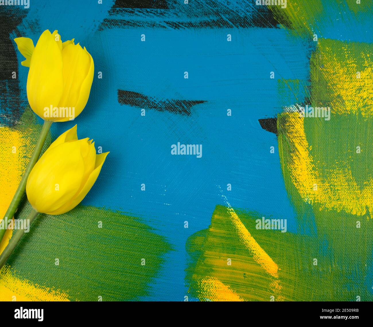 Foglie di eucalipto con bei tulipani gialli piatti posati su colorato fondo acrilico astratto fatto a mano. Composizione decentrata. Foto Stock