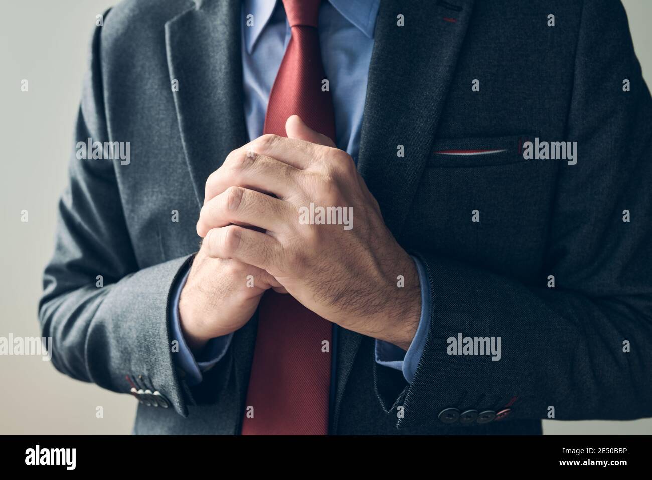 Uomo d'affari ansioso che stropiccia le mani, primo piano con fuoco selettivo Foto Stock