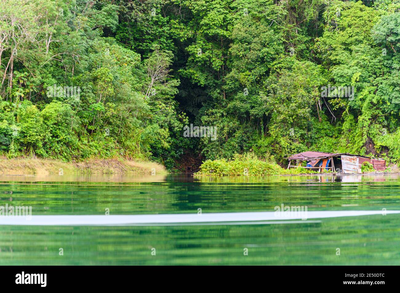 acqua limpida con riflesso verde e una casa abbandonata dentro La regione di Batang ai della Malesia Foto Stock
