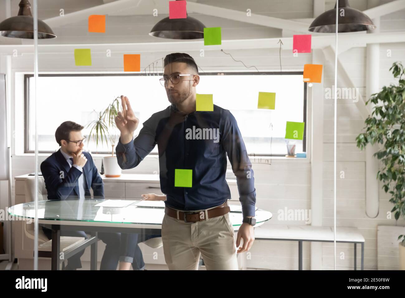 Uomo d'affari arabo sicuro che indossa occhiali lavorando sulla strategia di progetto Foto Stock