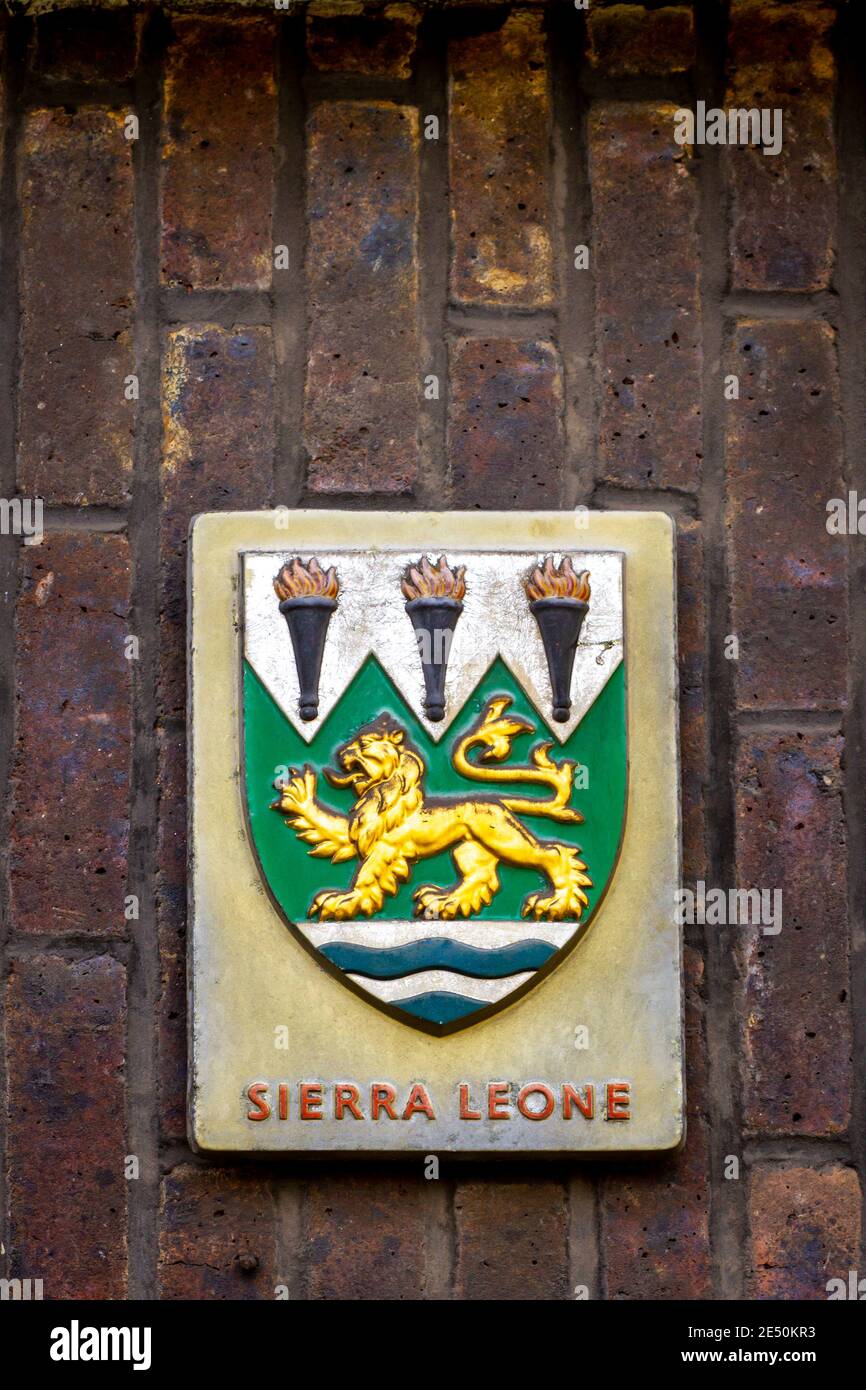 Stemma della Sierra Leone con un leone dorato con lingua esterna sopra le onde blu Foto Stock