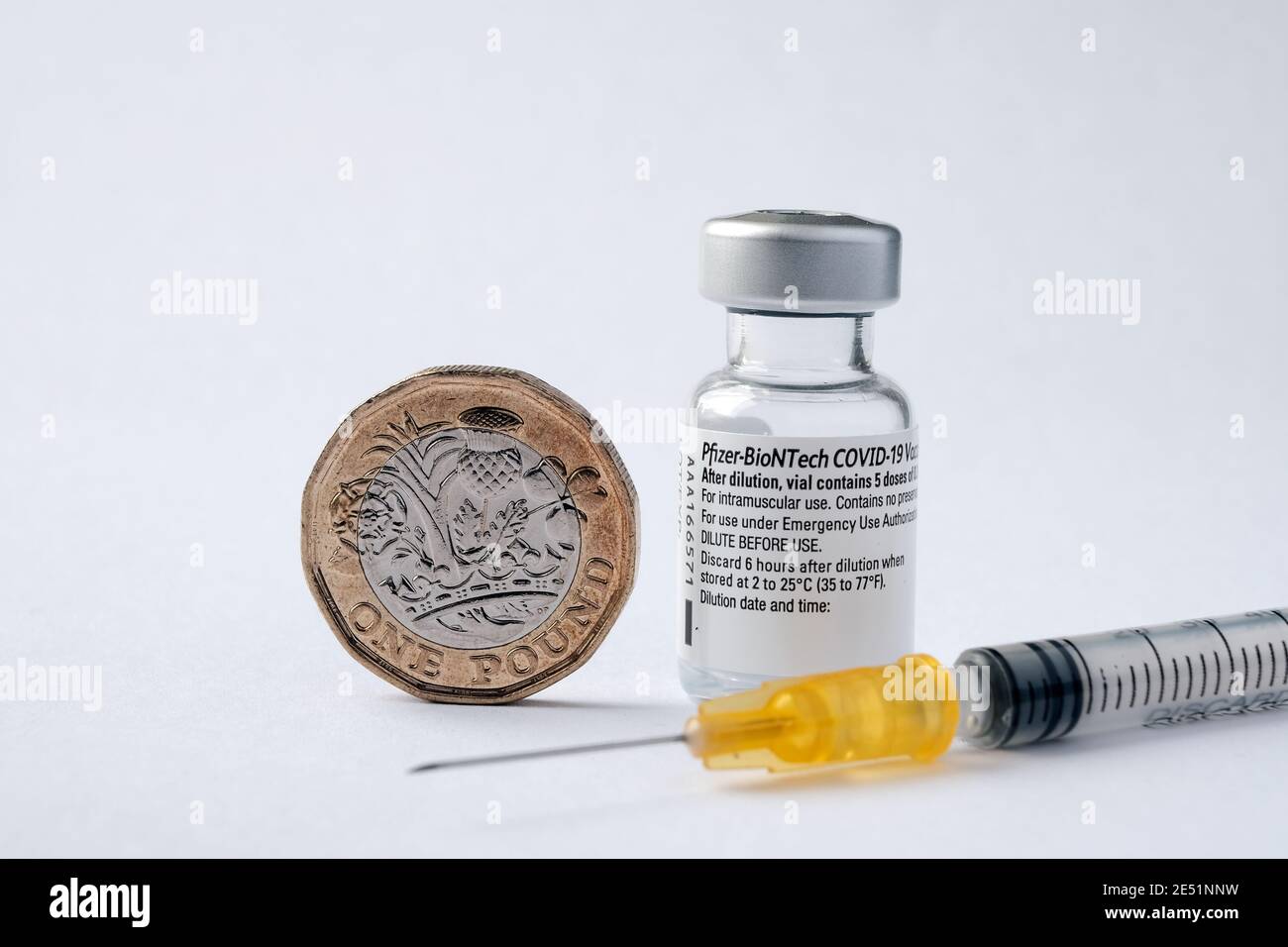 Flaconcino di vaccino originale Pfizer BioNTech COVID-19, siringa e moneta inglese da una libbra. Foto di vaccino reale. Messa a fuoco selettiva. Stafford, Regno Unito - Jan Foto Stock