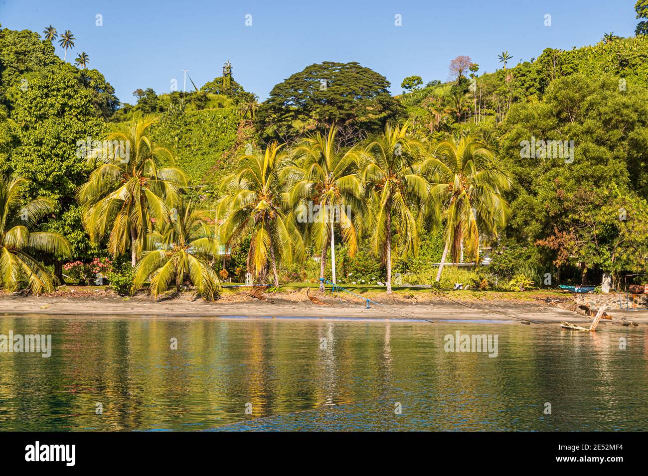 La costa al largo di Kieta, l'ex capitale di Bougainville, Papua Nuova Guinea. Alberi di palma e le rovine della casa sono la prova di una volta magnifica spiaggia di Kieta. Qui risiedevano i ricchi dipendenti della miniera di rame Panguna interna Foto Stock