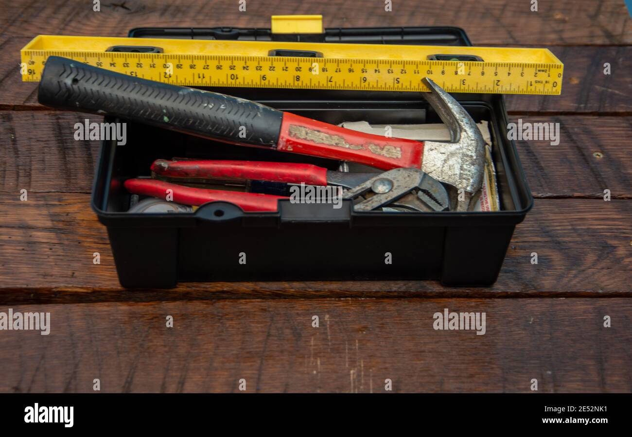 Attrezzatura in una cassetta attrezzi: Martello, righello, cacciavite, chiave, chiodi Foto Stock
