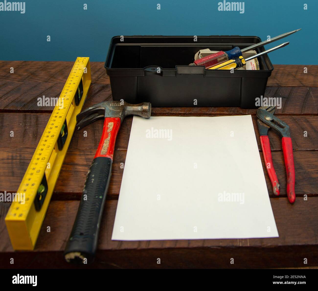 Toolbox con strumenti disposti su un tavolo con white paper Foto Stock