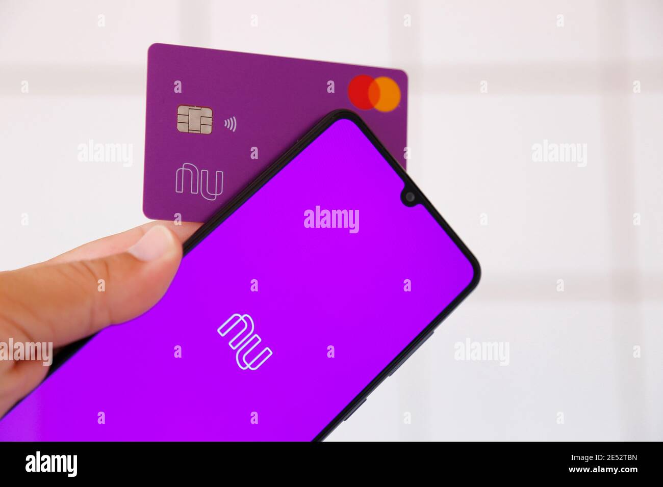 Minas Gerais, Brasile - 25 gennaio 2021: Display telefono cellulare e carta di credito con marchio Nubank e Mastercard. Sistema di pagamento digitale. Foto Stock