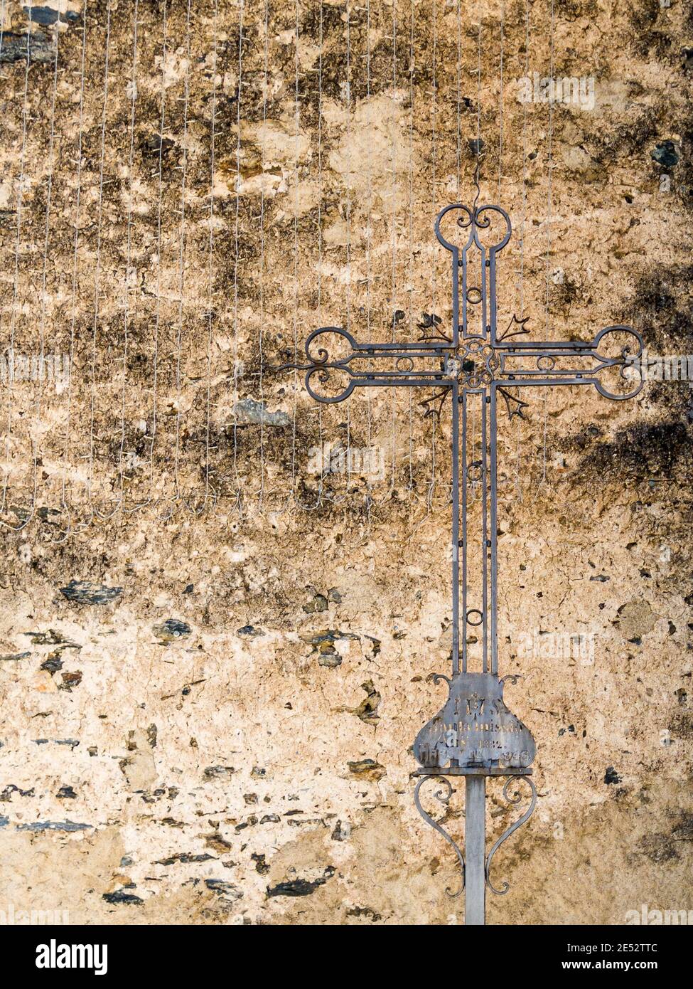 Una croce di metallo di fronte un edificio medievale a Ordino, Andorra Foto Stock