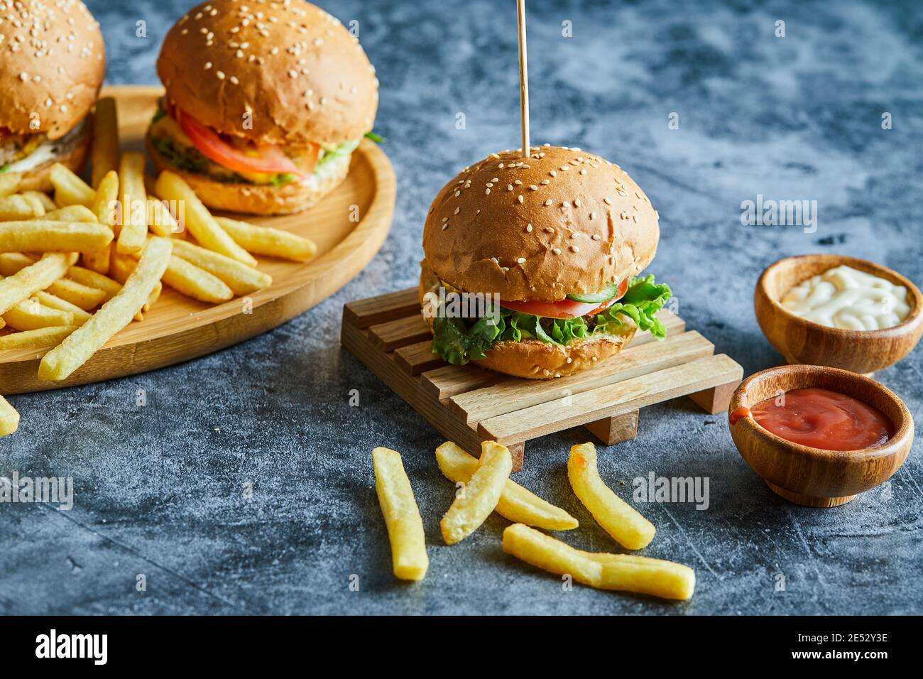 Cheeseburgers con patate fritte sulla tavola di legno Foto Stock