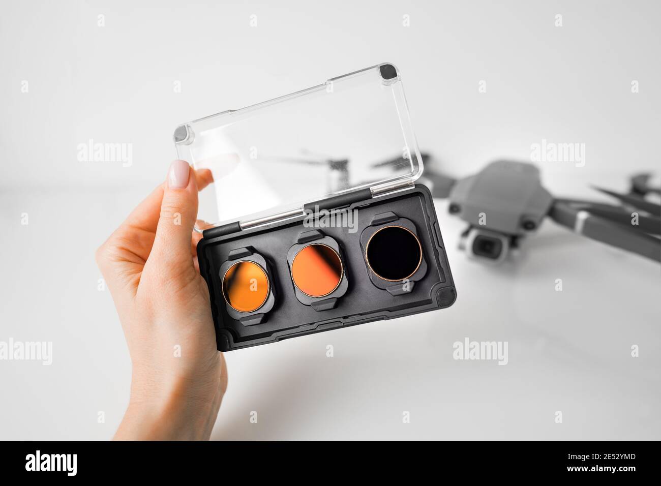 Mano donna con filtri ND e filtri polarizzanti per drone. Filtri per la telecamera drone. Foto Stock