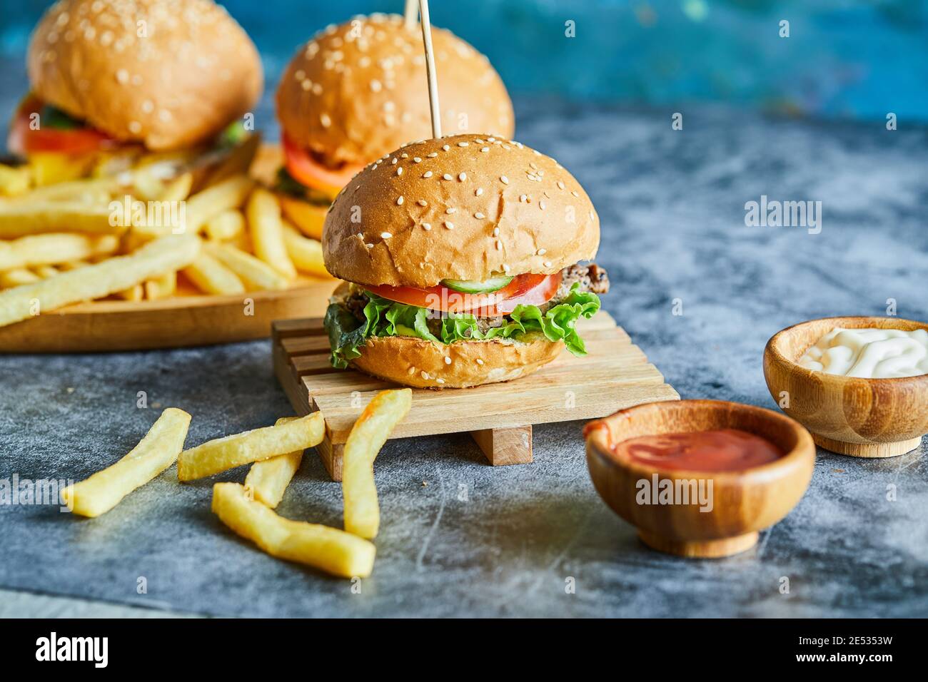 Cheeseburgers con patate fritte sulla tavola di legno Foto Stock