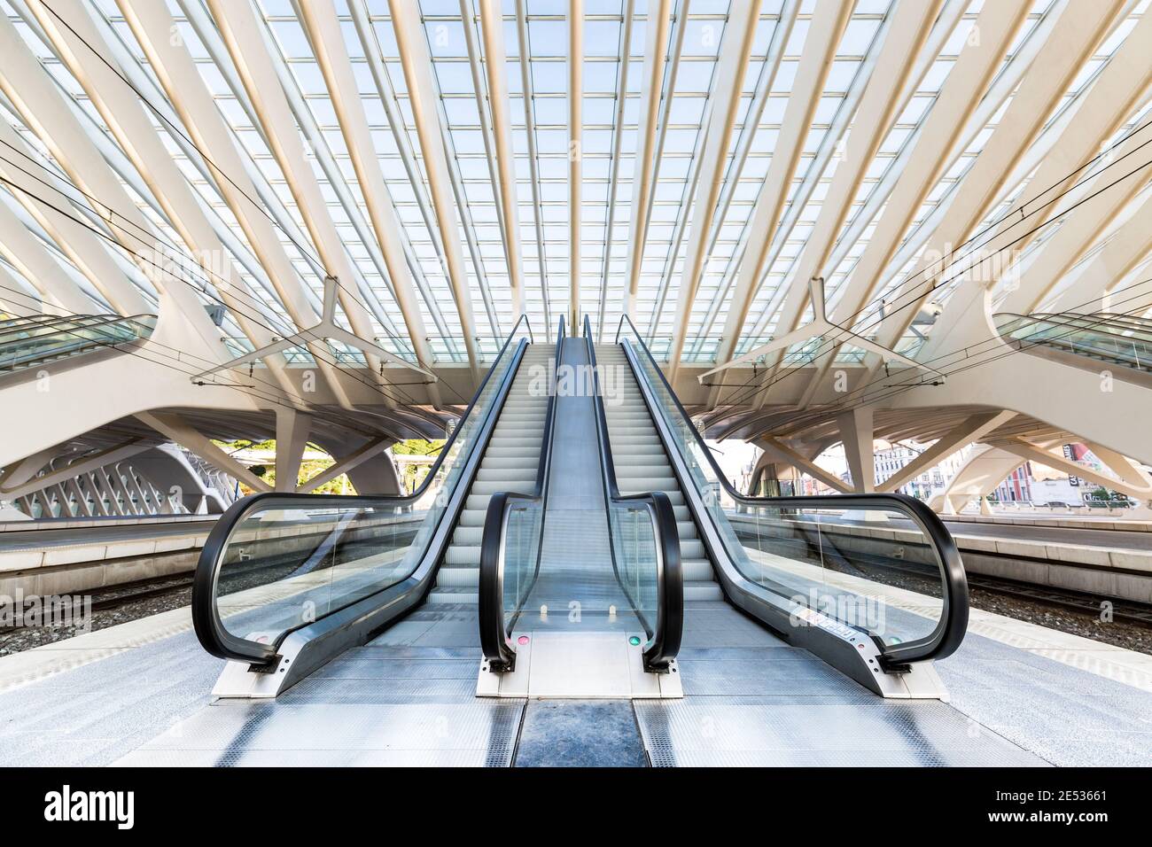 Vista grandangolare simmetrica di due scale mobili sulle piattaforme Della stazione ferroviaria di Liège-Guillemins Foto Stock