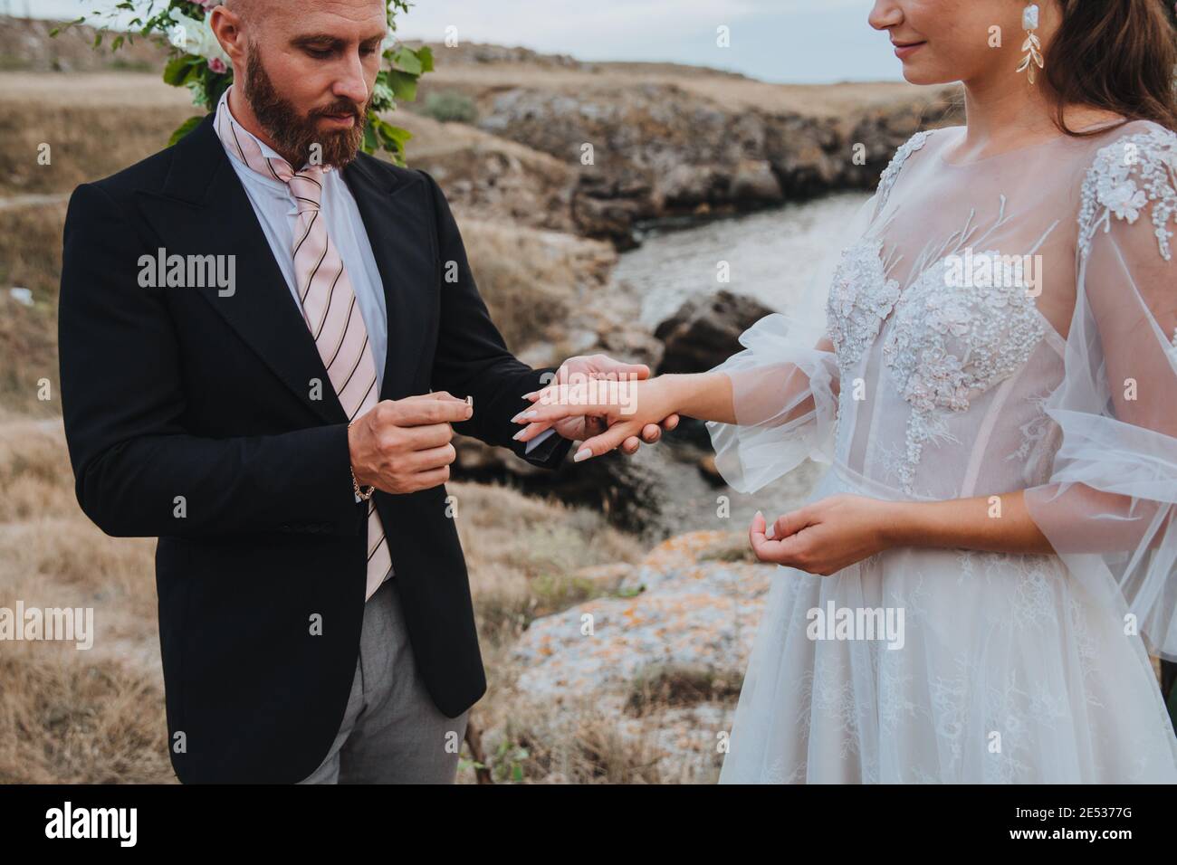 Un uomo propone ad una donna di impegnarsi mettendo un anello sul suo dito. Foto Stock