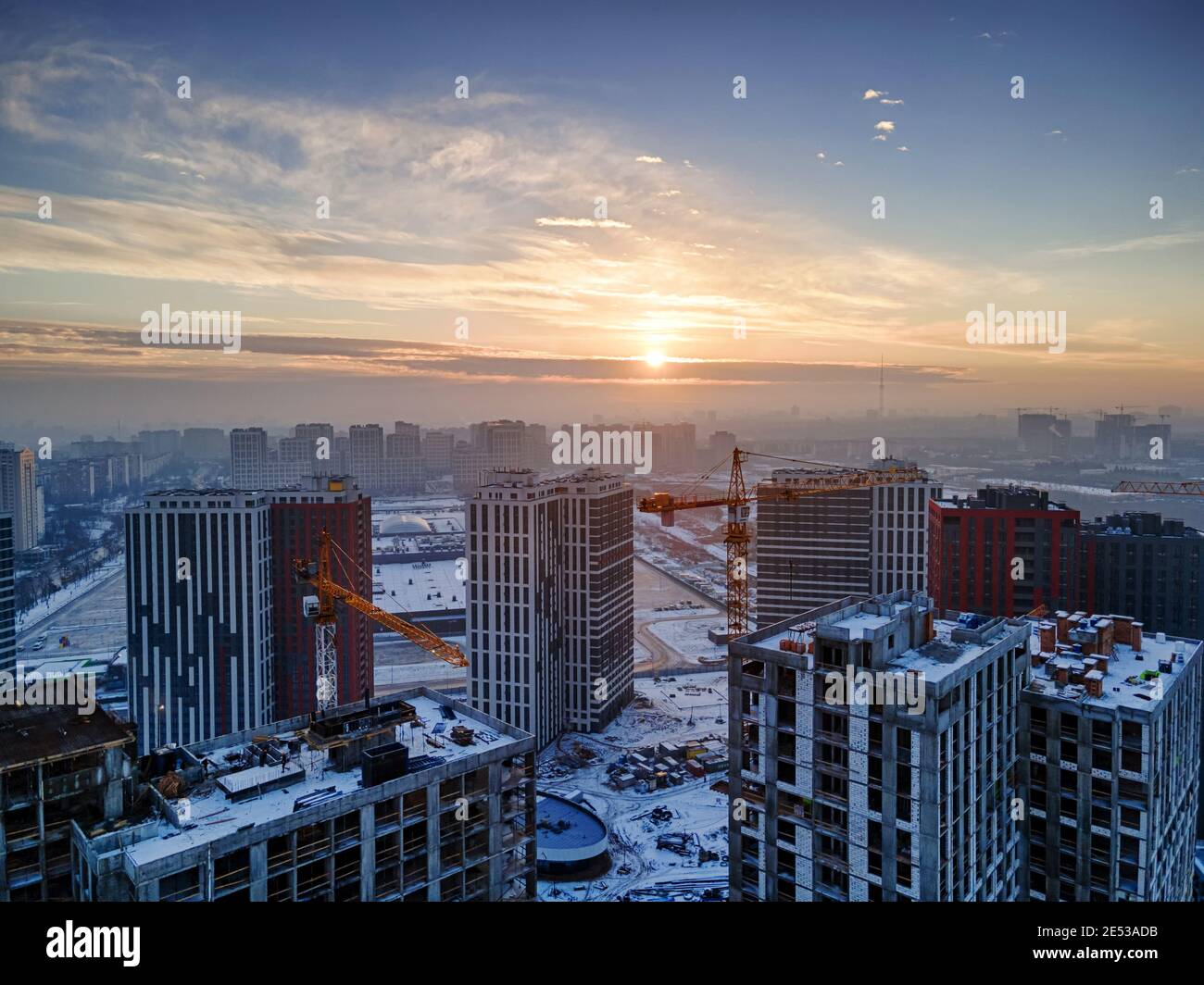 Immagine aerea di un grande cantiere che costruisce un nuovo quartiere residenziale. Bella alba invernale Foto Stock