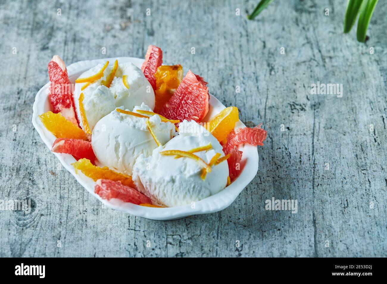 Gelato con pompelmo e fette di arancia in ciotola bianca Foto Stock