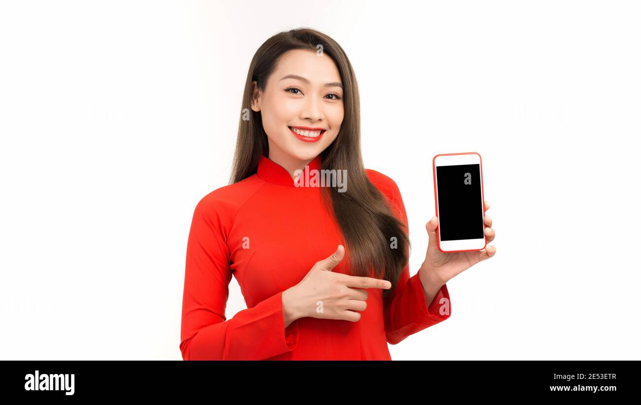 Giovane bella donna asiatica che indica lo spazio vuoto nero su lo sfondo dello smartphone può essere utilizzato per la pubblicità o la presentazione del prodotto concetto Foto Stock
