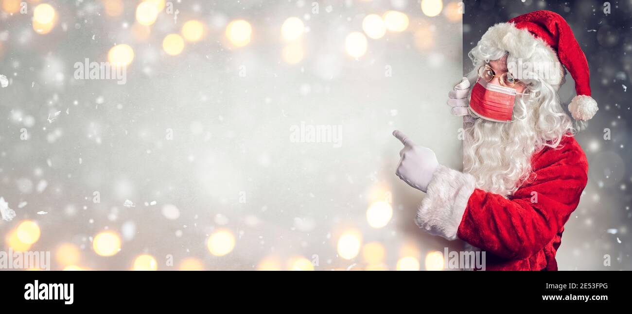 Babbo Natale con maschera protettiva che punta in bianco Affissioni Foto Stock