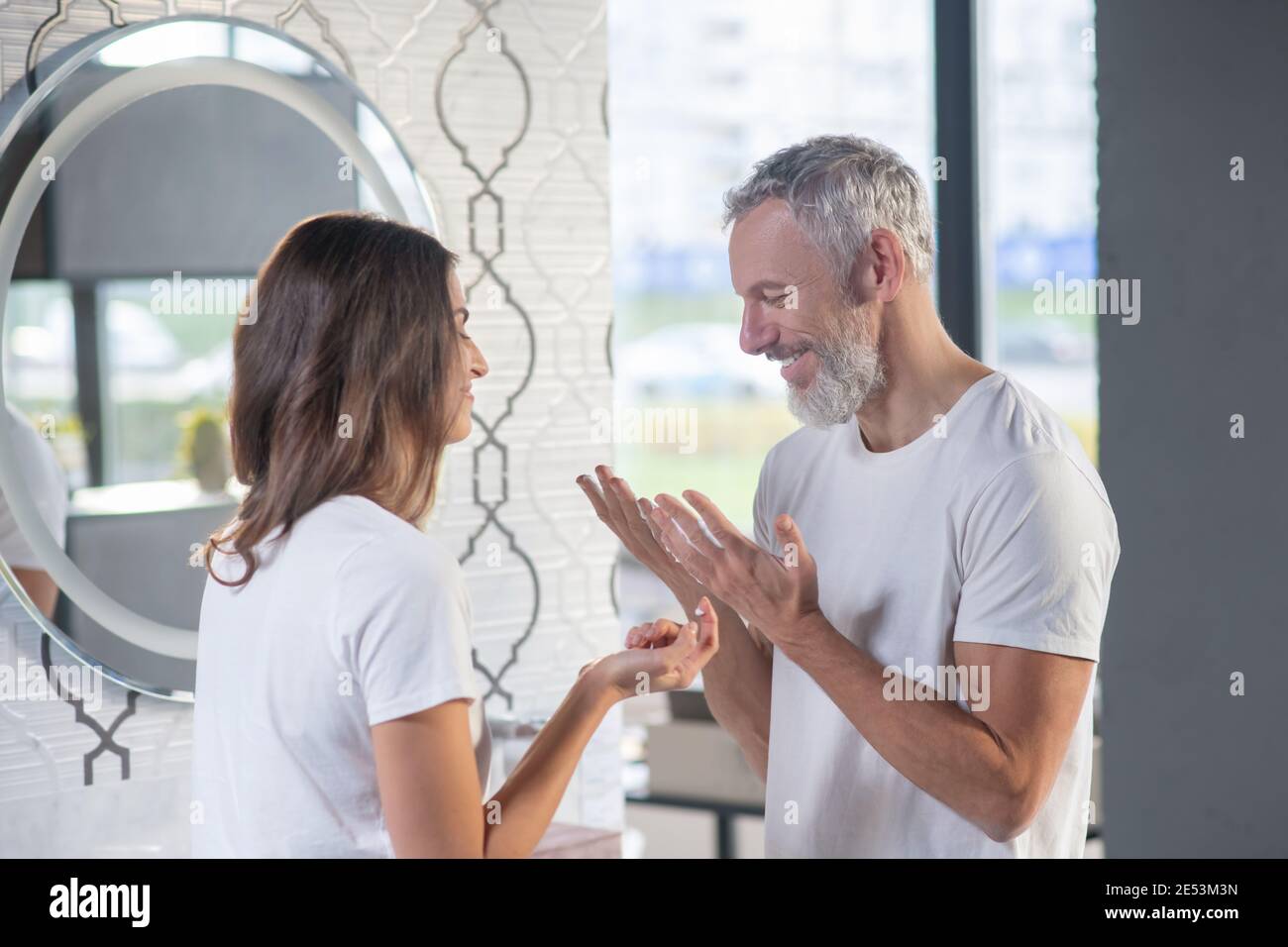 Uomo gioioso e donna che si levano in piedi l'uno di fronte all'altro Foto Stock