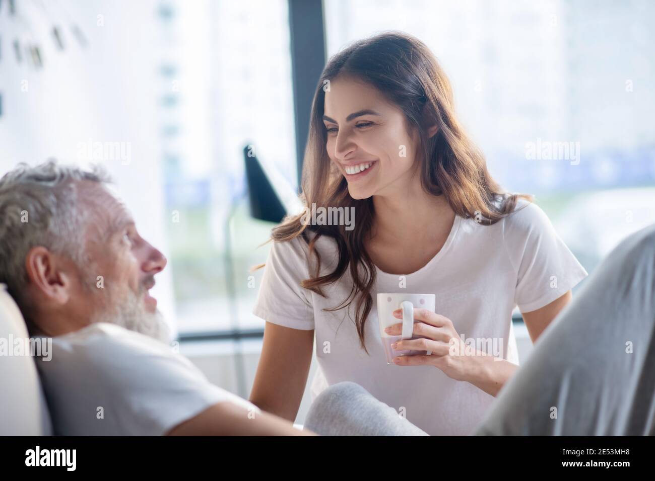 Donna felice con coppa e uomo in profilo Foto Stock