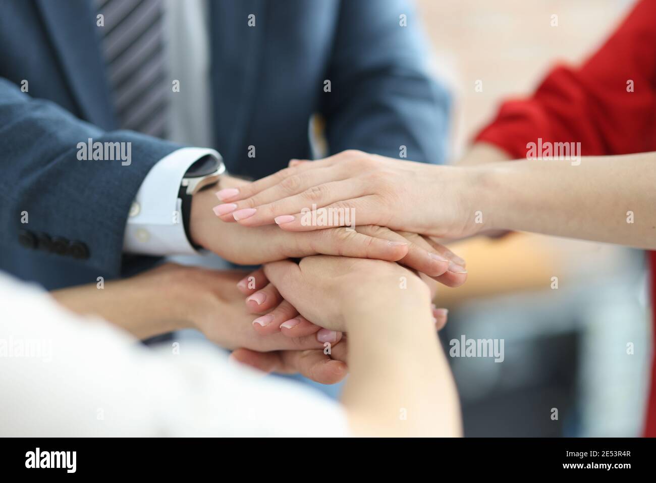 Gli uomini d'affari che si piegano le mani insieme nel guardaroba dell'ufficio Foto Stock